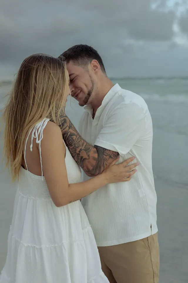 Couple touching foreheads on a cloudy beach