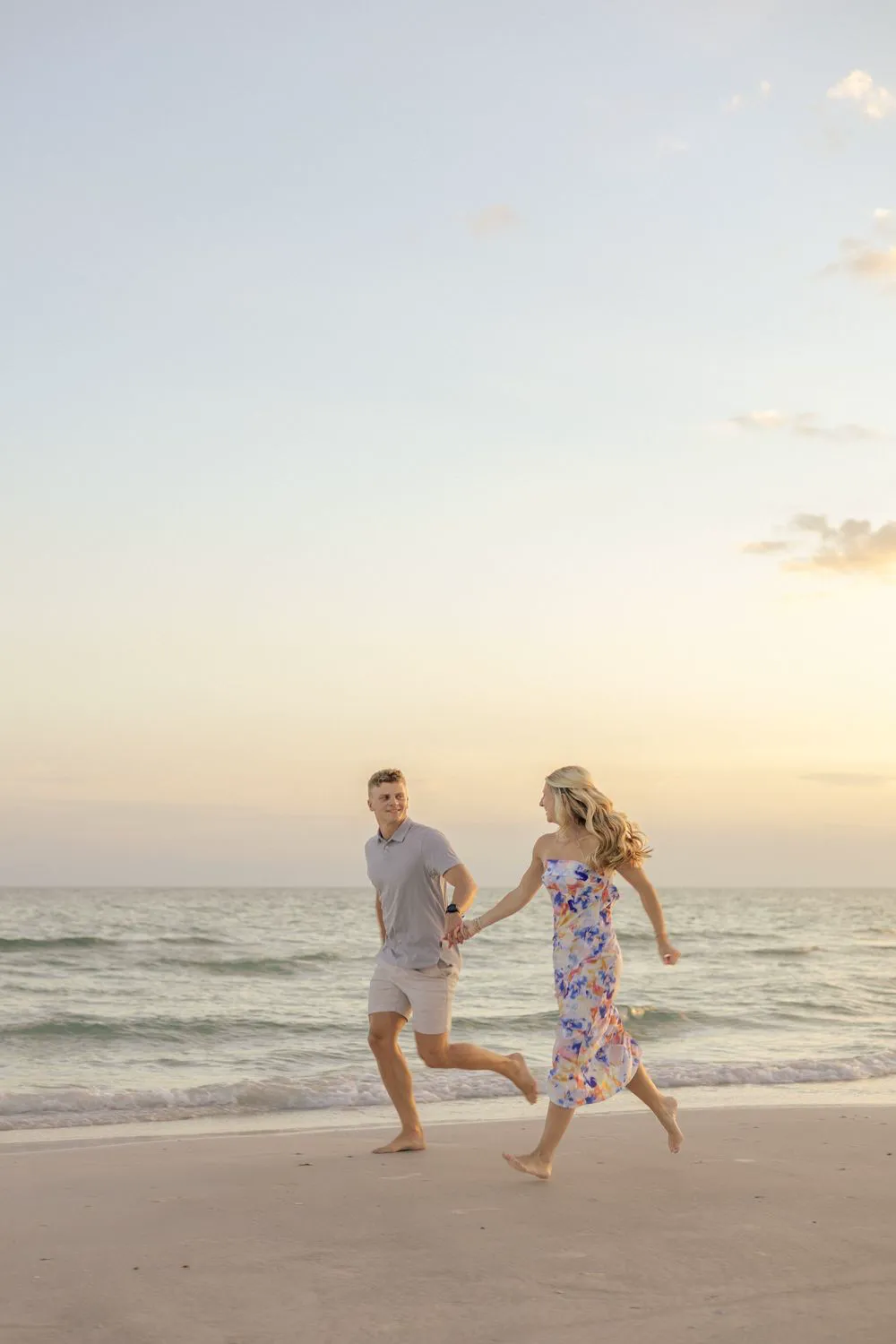 Couple running hand in hand along the shoreline