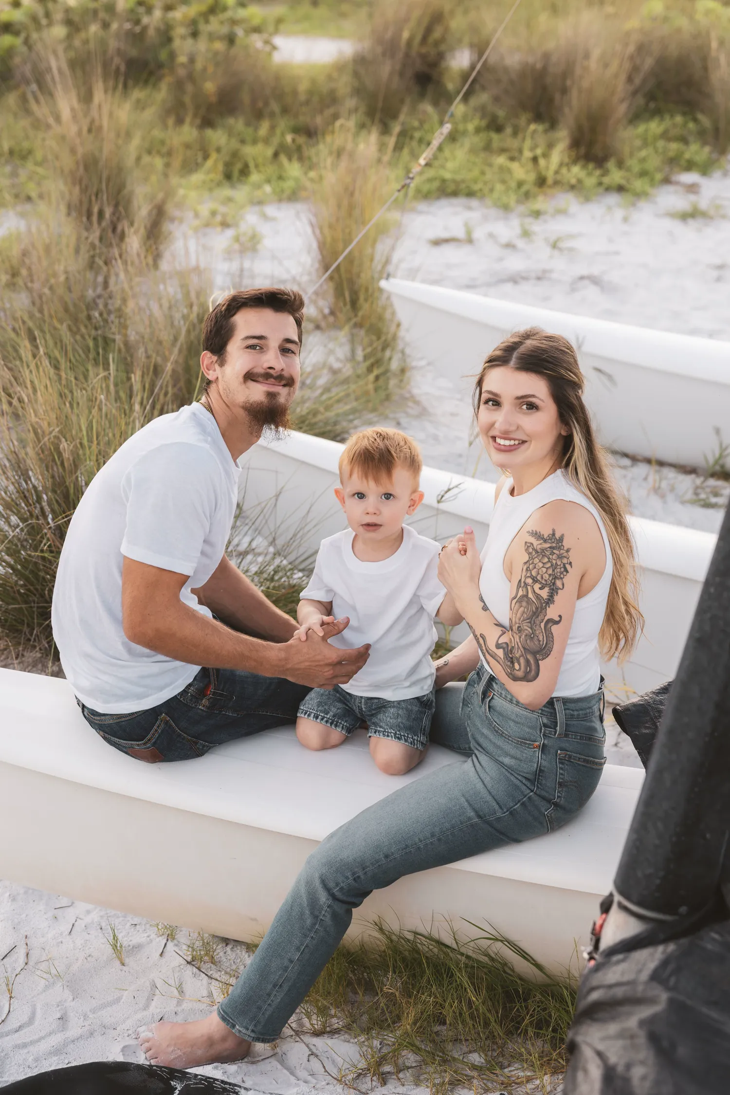 Family sitting on a white boat in the dunes