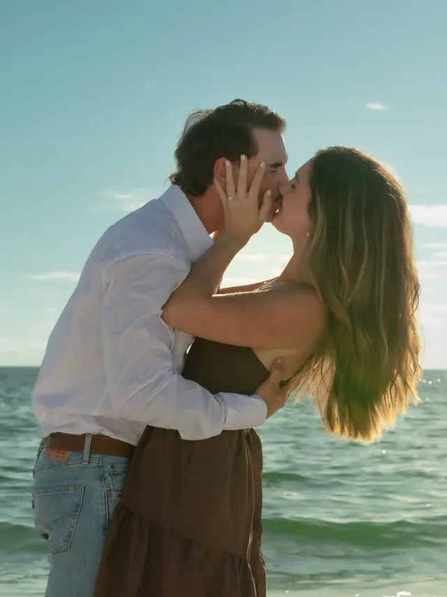 Couple kissing by the water on a sunny day